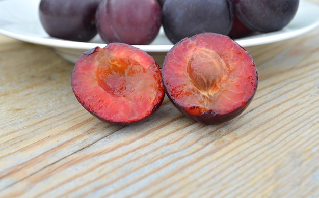 Closeup of ripe sliced plums in a bowl selective focus