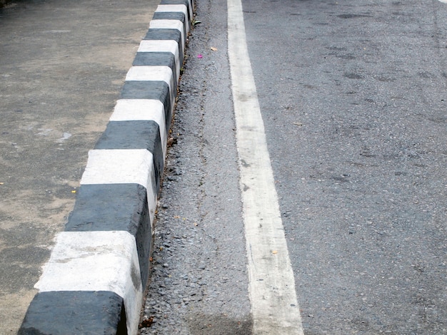 closeup of road with brown and white line    