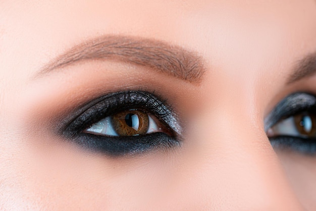 Closeup rokerige make-up oog donkere oogleden. vrouwelijke ogen met mooie heldere mode-stijl.