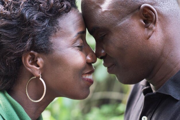 Foto close-up di una coppia romantica in piedi faccia a faccia e abbracciandosi in campagna