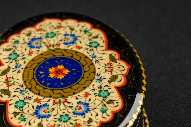 A closeup of a round casket with an artistic painting on a black background Central Asia Uzbekistan