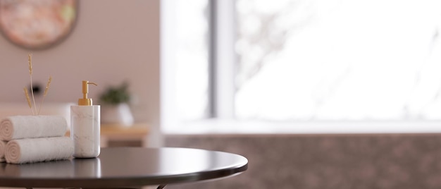 Closeup Round table with shampoo bottle and towels over blurred bathroom in the background