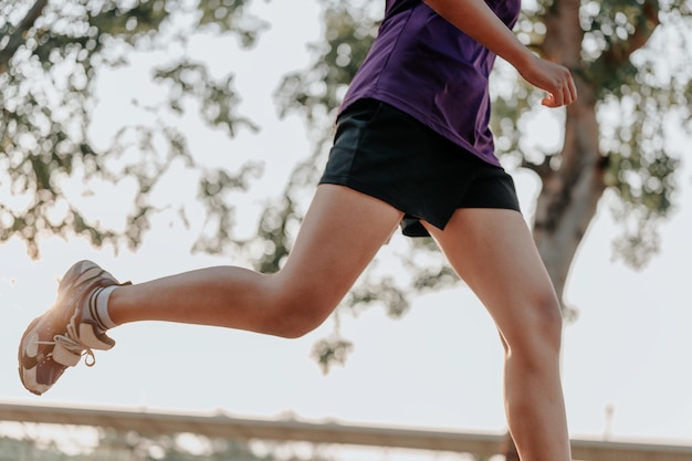 Closeup of the runner's legs when running in the evening with sunlight.Practice jogging in the evening