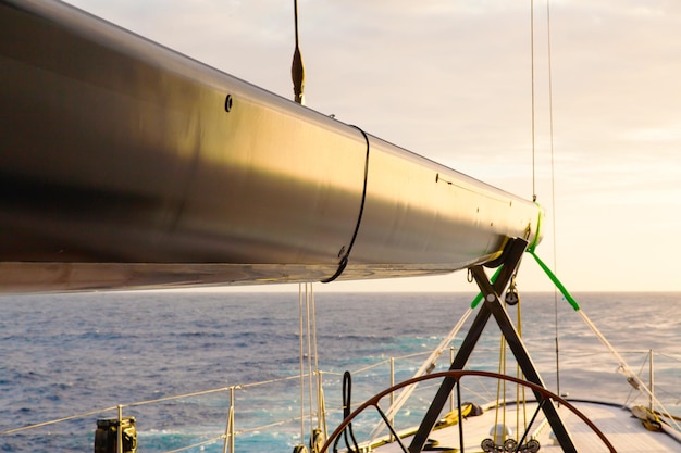 Closeup of a sailing yacht in the sea at sunset