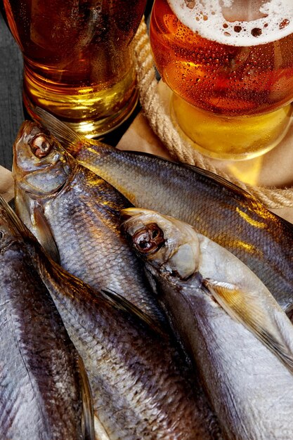 앰버 맥주와 함께 소금에 절인 공기 건조 바퀴벌레 물고기, 사브르피쉬, 농어의 근접 촬영