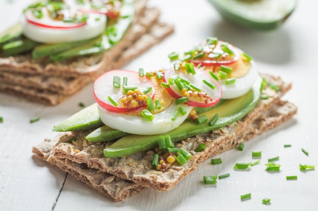 Closeup of sandwich with avocado radish and eggs