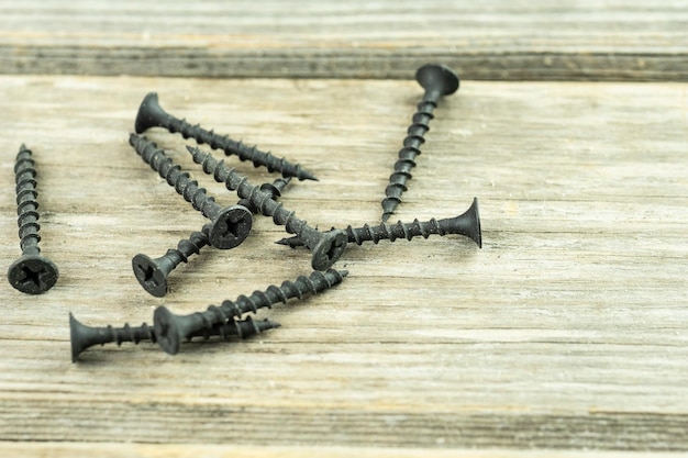 Closeup of scattered large long black screws A poster for a building materials store or catalog Building a house