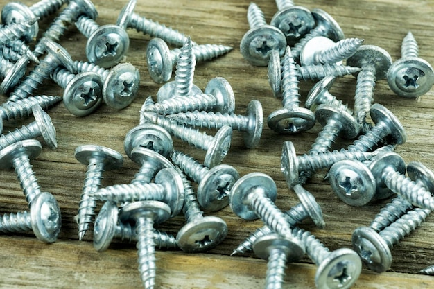 Closeup of scattered large long new screws. Building a house or assembling furniture