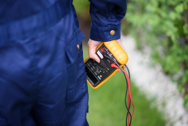 Closeup scene of the electrician holding a multimeter