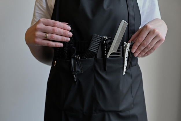 Closeup of scissors and combs in a holster box Hairdressing tools inside a hairdresser's waist bagCloseup of scissors and combs in a holster box Hairdressing tools inside a hairdresser's waist bag