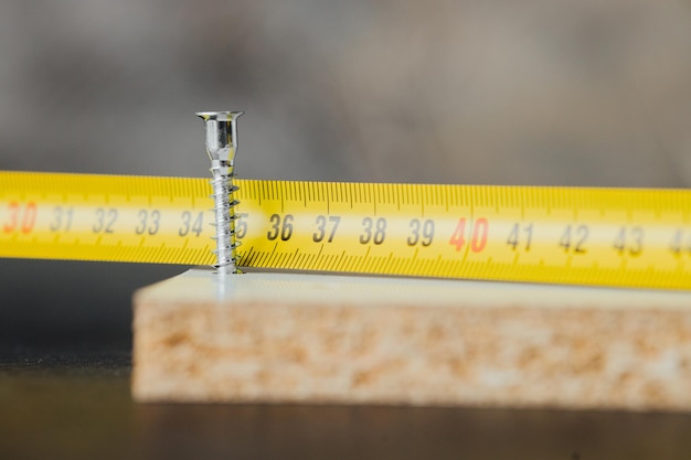 Closeup of screw being screwed into a wooden plank - macro shoot