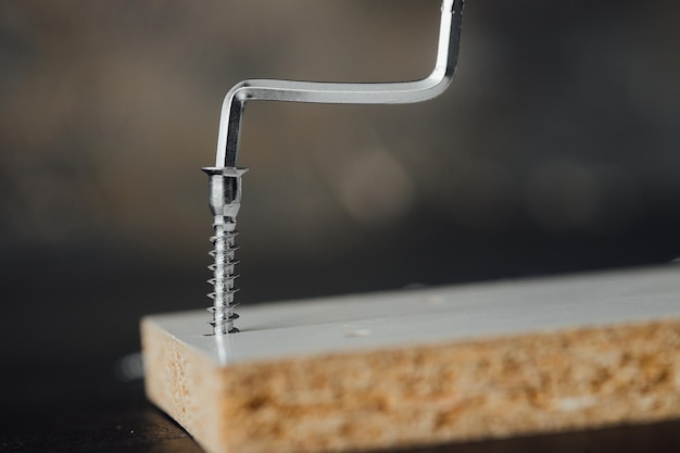 Closeup of screw being screwed into a wooden plank - macro shoot