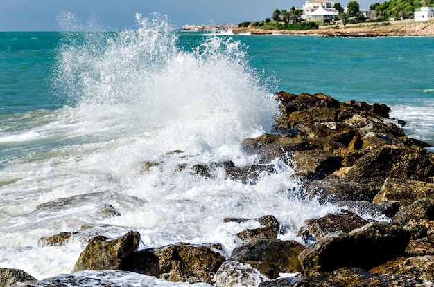 Closeup of sea waves breaking on the rocks of Vilanova y la Geltru beach