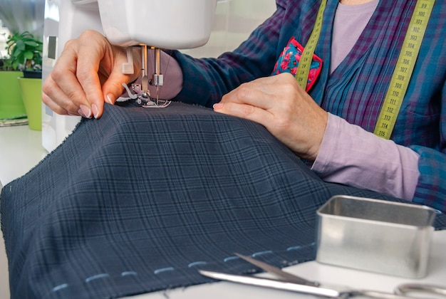 Closeup of seamstress hands working with clothing item on a sewing machine