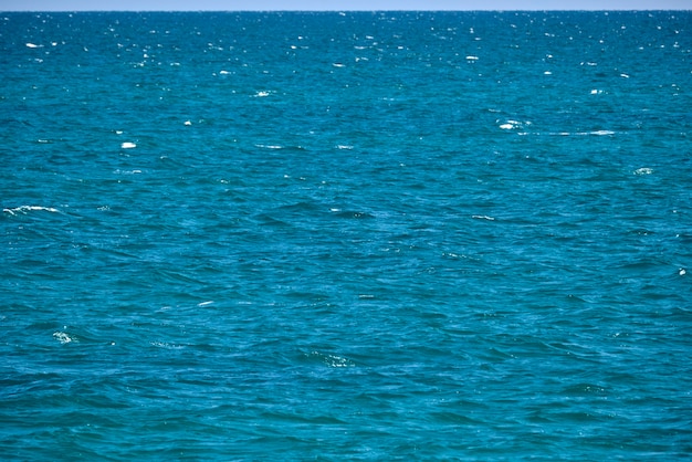 Superficie marina del primo piano dell'acqua di mare blu con piccole onde dell'ondulazione