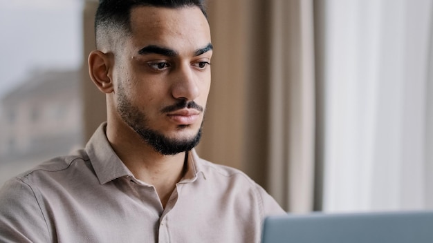 Closeup serious concentrated male portrait arab businessman guy hispanic man freelancer sit at home