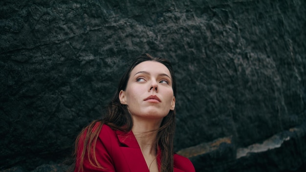 Closeup serious stylish lady in red elegant suit posing camera confidently