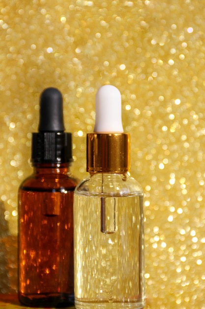 Closeup of serum in glass bottles on a gold background Cosmetics and care