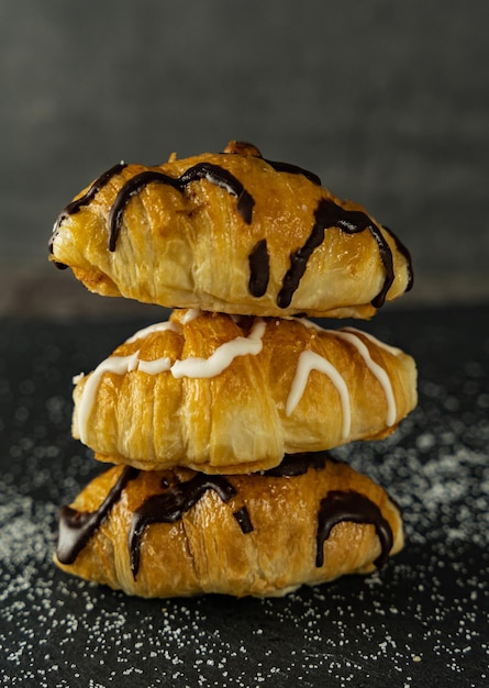 Closeup of a set of three tasty croissants on a dark background