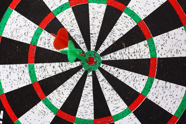 Closeup. several Arrows dart hitting the center of the target dart Board.the concept of purpose.