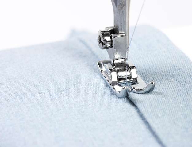 Closeup of sewing machine and blue fabric