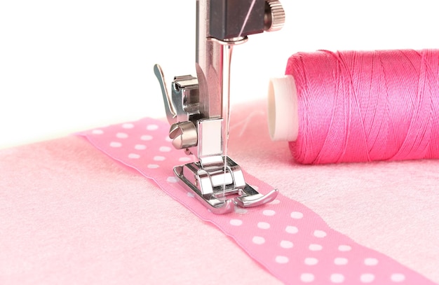 Closeup of sewing machine working part with pink cloth