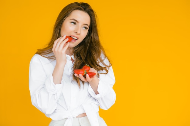 Closeup of a sexy female eating fresh strawberry Sexual lips red lipstick Healthy food concept