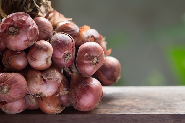 Closeup of shallot on wooden table on vintage kitchen