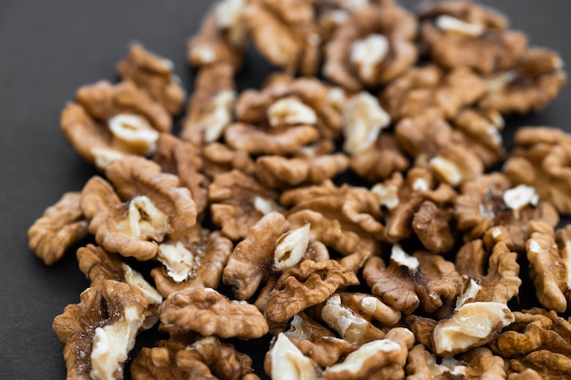 Closeup of shelled organic walnut halves on black background