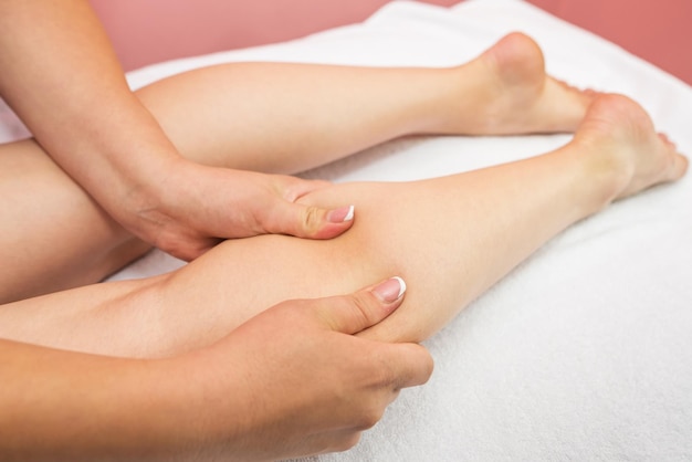 Closeup shin massage Anticellulite foot massage in spa salon