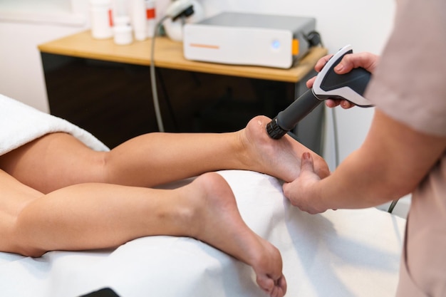 Closeup of shockwave therapy on ankle to alleviate joint and muscle pain