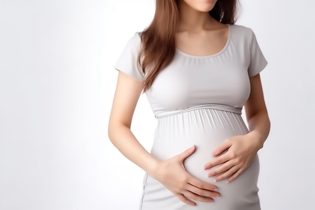 Closeup shoot of pregnant woman in white gown expecting her baby