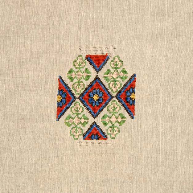 A closeup shot of an abstract colorful embroidery design on a beige cloth