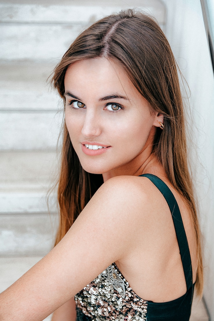 Photo closeup shot of an attractive brunette girl staring at the camera while sitting on the stairs