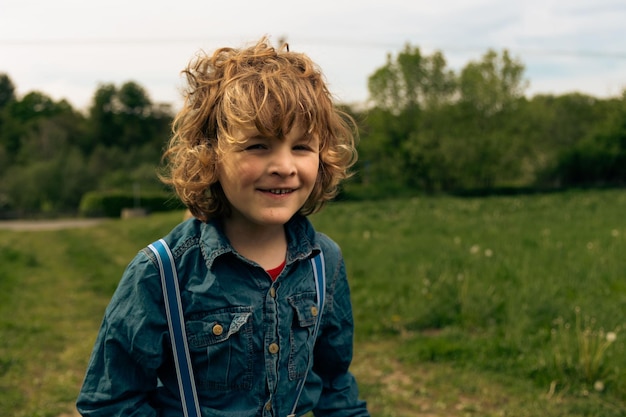 Closeup shot of an autistic Caucasian baby boy with blonde hair playing in a park on a sunny day