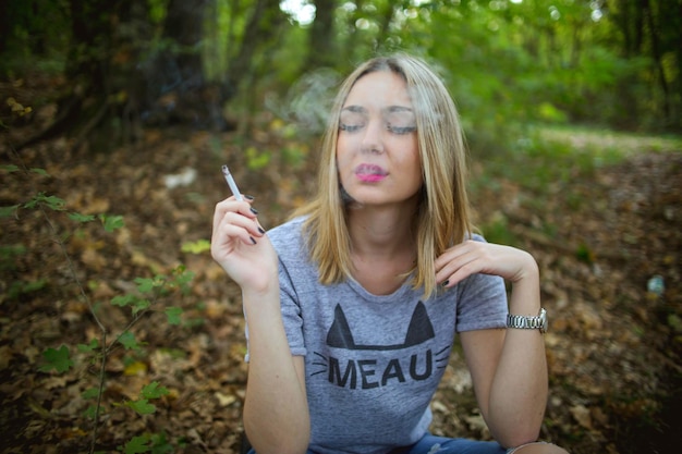 Photo closeup shot of a beautiful caucasian blonde woman smoking a cigarette