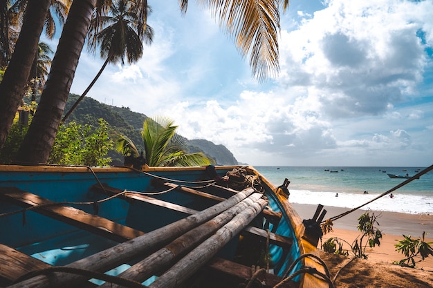 Closeup shot of a blue wooden boat on the shore of a sea