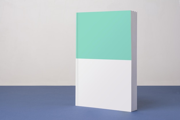 Closeup shot of a book with a blank cover on a blue ground against a white background