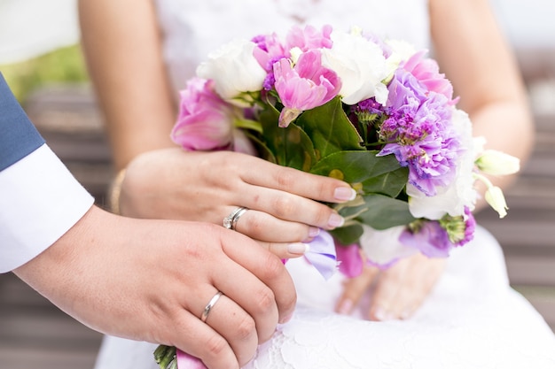 Closeup shot of bride and groom holding beautiful bridal bouquet