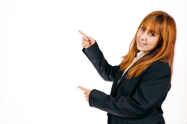 A closeup shot of a businesswoman pointing at a space on an isolated wall