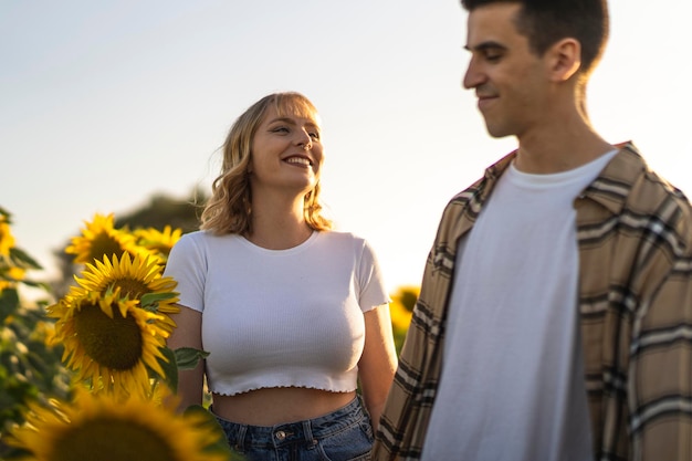 Closeup shot of a Caucasian lovely couple at the sunflowers field in Spain