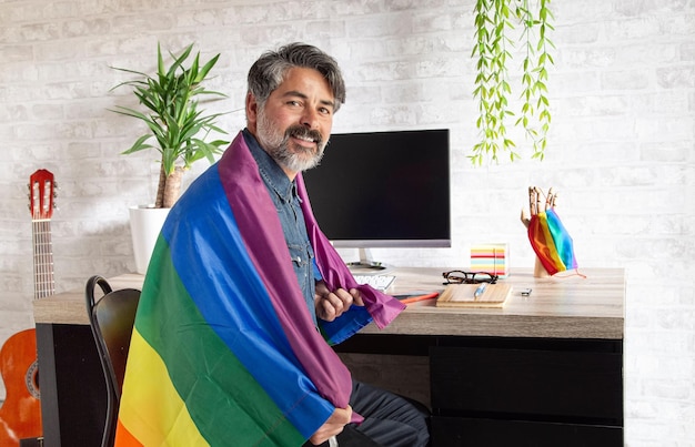 Closeup shot of a Caucasian man proudly showing a pride flag