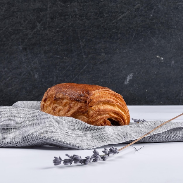 Closeup shot of a chocolatine on a towel with a dark background