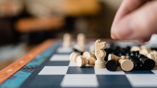 Closeup shot of choosing white knight chess pieces standing on a chessboard amongst the pawns and others on the floor a game for strategic challenges and competitions