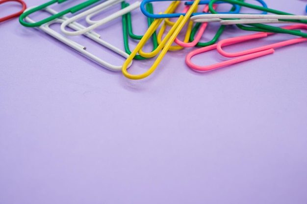 Closeup shot of colorful paper clips on a purple background