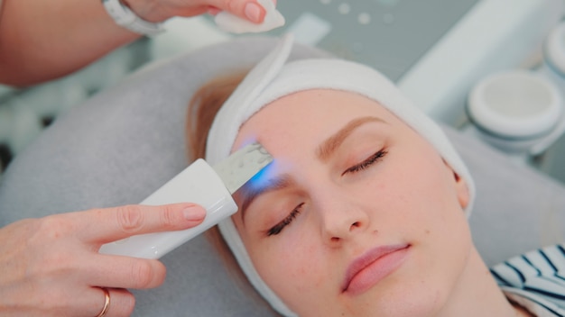 Photo closeup shot of cosmetician making cavitation facial peeling woman resting after hard working week