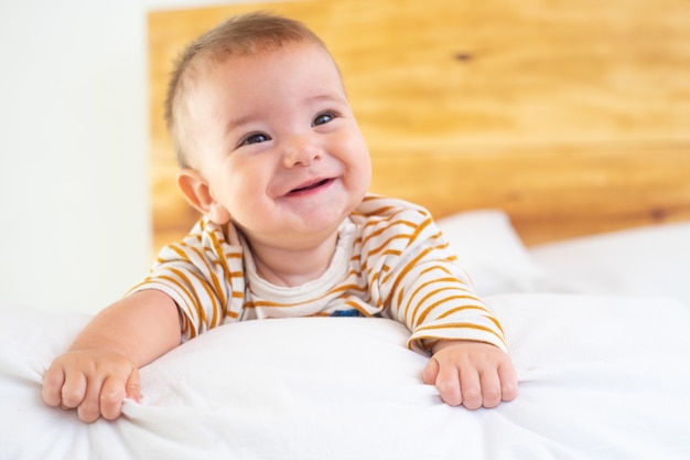 Closeup shot of a cute smiling baby on a bed