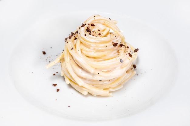 Closeup shot of a delisous vegan pasta dish on a white plate