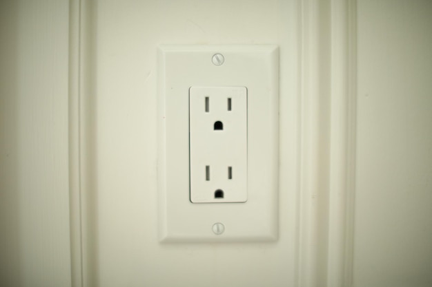 Closeup shot of an electric plug outlet installed in a white wall