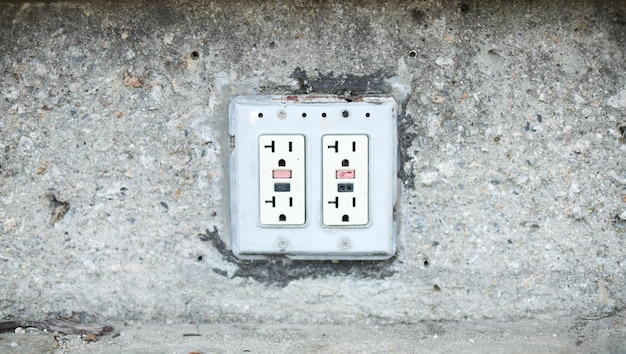 Closeup shot of an electric plug outlet installed in a white wall